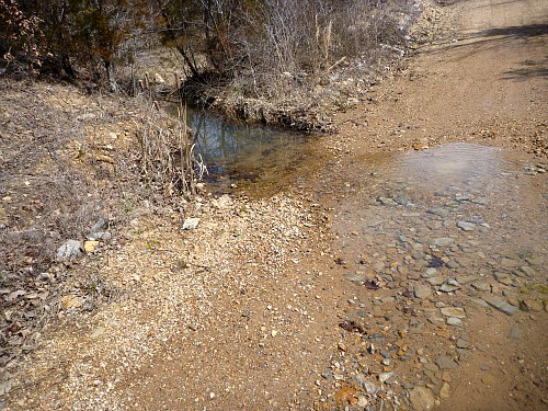 A trickle of water across the road.