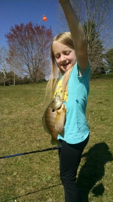 Young girl showing off her first fish