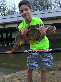 Small child holding large carp