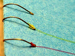 Close-up of three snelled tanago hooks.