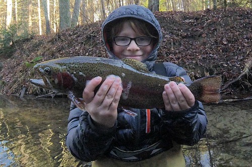 Smiling angler holding large rainbow trout