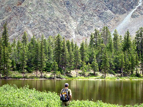 Angler approaching a beautiful high mountain lake