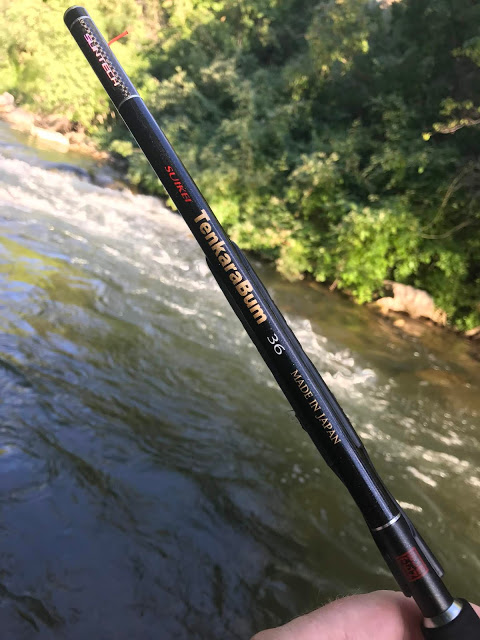 Angler holding TenkaraBum 36 rod, with stream in background