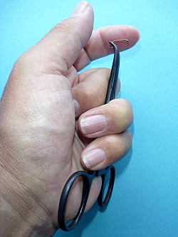 Clamps held in hand so that thumb and forefinger are free to hold materials