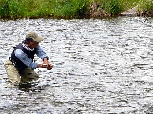 Oni holding rod to the side, low to the water