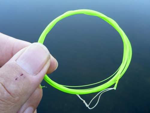 Bright green Tenkara Midi with blue water in background