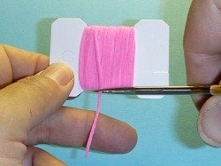 Angler using width of card to measure where to cut chenille.