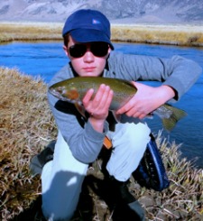 Young angler holding large rainbow trout